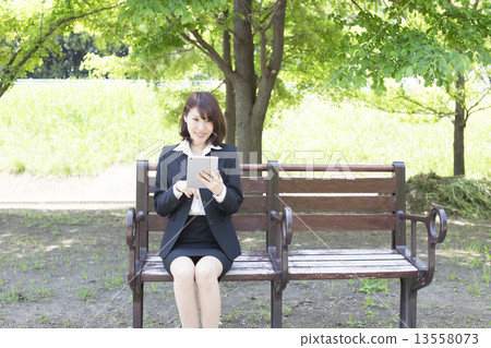 女商人觀看的片劑在公園 女商人觀看的片劑在公園 13558073