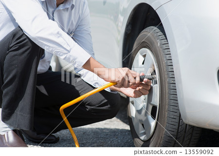 Filling air to the car tires. Filling air to the car tires. 13559092