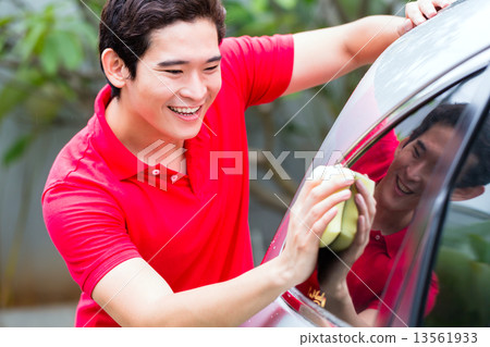 Asian man cleaning and washing car with sponge 13561933