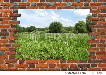 hole in the brick wall and view to summer field 13563209