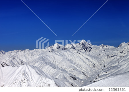 Snowy mountain peaks in sun day 13563861