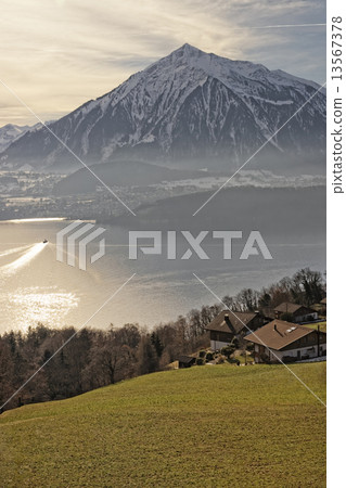 Sunrise in a village over the Thun lake in Swiss Alps in winter 13567378