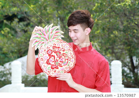 Man in Chinese Cheongsam holding Pineapple Chinese New Year sign 13570987
