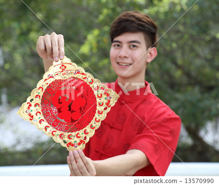 Man in Chinese Cheongsam holding Chinese New Year sign Focus on Sign 13570990