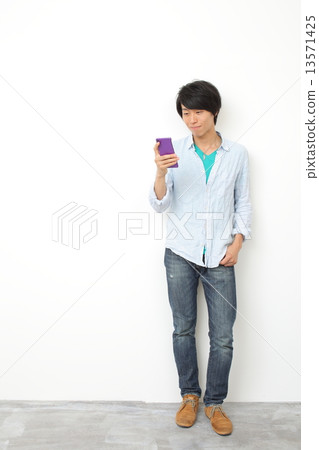 Male in twenties using a smartphone 13571425