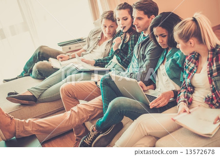 Group of students preparing for exams in apartment interior Group of students preparing for exams in apartment interior 13572678