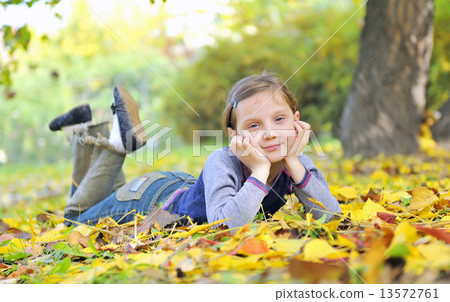 little girl  laying on the grass 13572761