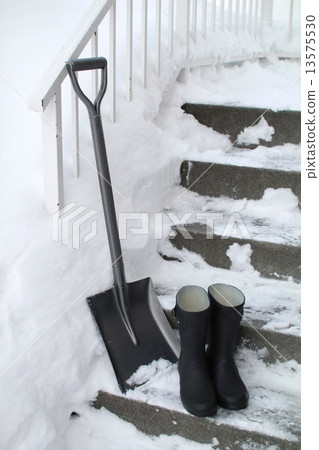 A shovel and boots placed on snow-covered concrete stairs A shovel and boots placed on snow-covered concrete stairs 13575530