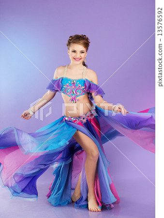 Beautiful belly dancer wearing a purple costume 13576592