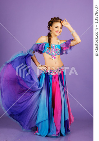 Beautiful belly dancer wearing a purple costume 13576637