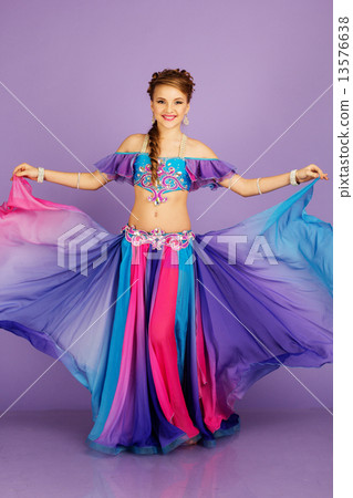Beautiful belly dancer wearing a purple costume 13576638