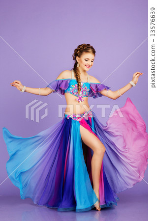 Beautiful belly dancer wearing a purple costume 13576639
