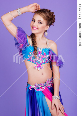 Beautiful belly dancer wearing a purple costume Beautiful belly dancer wearing a purple costume 13576644