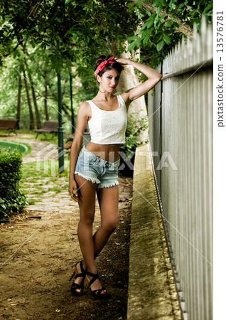 Pin-up girl. American style, in a garden Pin-up girl. American style, in a garden 13576781
