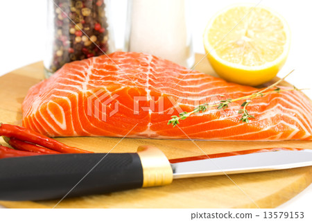 raw salmon steak with lemon and spices on a cutting board 13579153