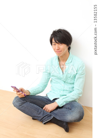 Male in twenties using mobile phone 13582155