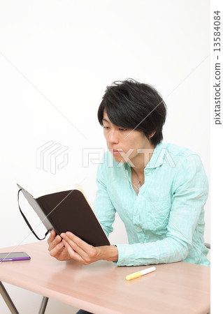 A man sitting in a chair and touching a notebook 13584084