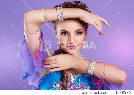 Beautiful belly dancer wearing a purple costume 13588580