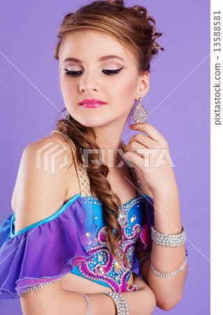 Beautiful belly dancer wearing a purple costume Beautiful belly dancer wearing a purple costume 13588581