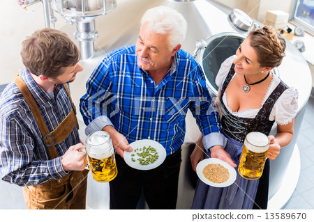 Brewer and couple in beer brewery guided tour 13589670