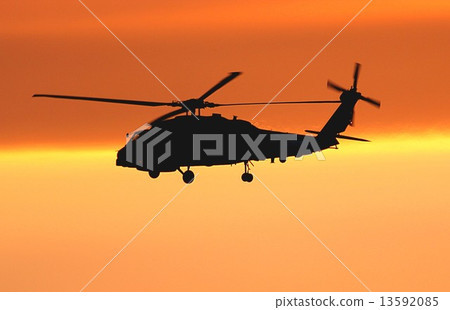 U.S. Navy SH-60B Sea Hawk ship's anti-submarine helicopter flying against a background of bright sunset 13592085