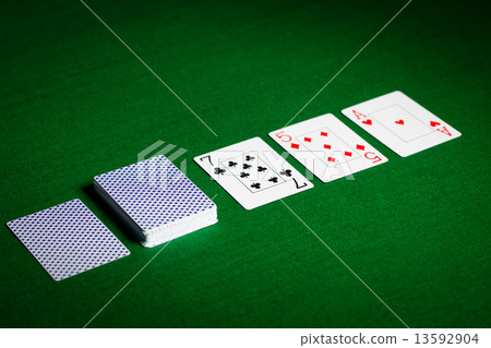 playing cards on green table surface 13592904