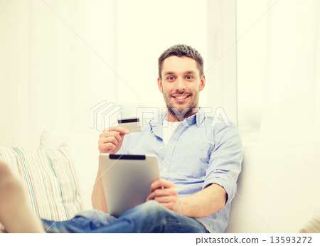 smiling man working with tablet pc at home smiling man working with tablet pc at home 13593272