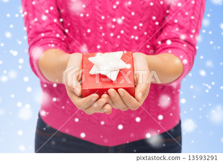 close up of woman in pink sweater holding gift box 13593291