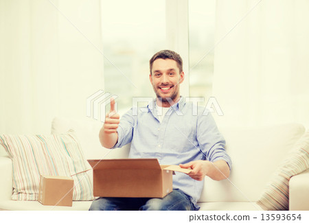 man with cardboard boxes at home showing thumbs up man with cardboard boxes at home showing thumbs up 13593654
