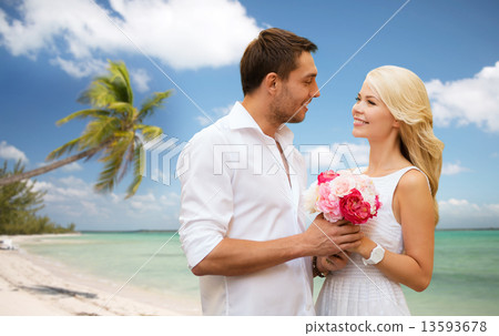 happy couple with flowers over beach background happy couple with flowers over beach background 13593678
