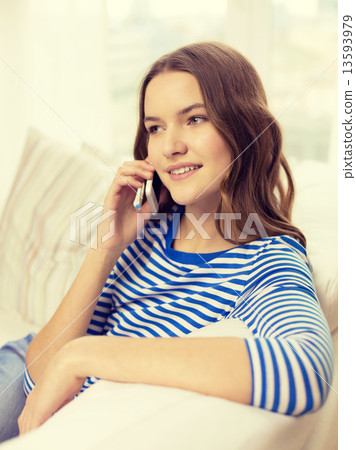 smiling teenage girl with smartphone at home 13593979