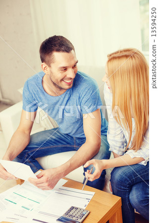 smiling couple with papers and calculator at home smiling couple with papers and calculator at home 13594250