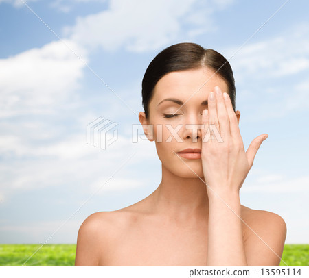 smiling young woman covering face with hand smiling young woman covering face with hand 13595114