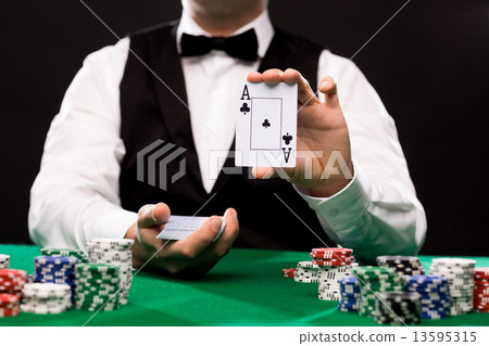 holdem dealer with playing cards and casino chips 13595315