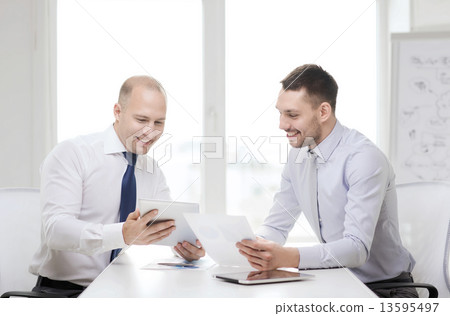two smiling businessmen with tablet pc in office two smiling businessmen with tablet pc in office 13595497