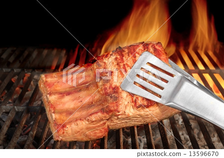 Tongs Holding Grilled Pork Ribs 13596670