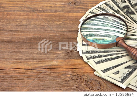 Fake Hundred dollar banknote under magnifying glass 13596684