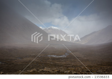 field against the background of distant colorful mountain range 13596833