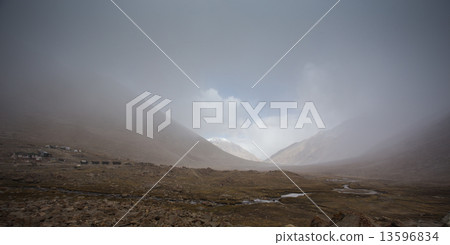 field against the background of distant colorful mountain range 13596834