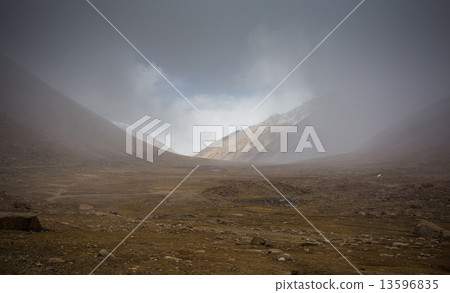 field against the background of distant colorful mountain range 13596835