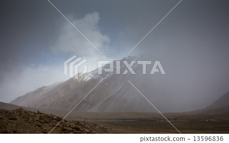 field against the background of distant colorful mountain range 13596836