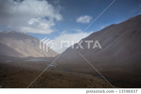 field against the background of distant colorful mountain range 13596837