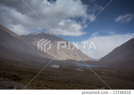 field against the background of distant colorful mountain range 13596838