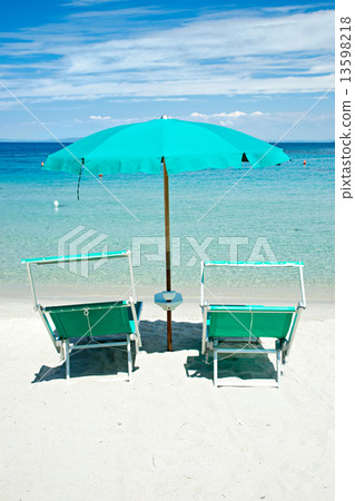 Two beach chairs with green umbrella. 13598218
