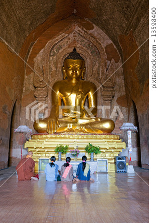 A monk and three women praying inside htilominlo Temple, Bagan, 13598400
