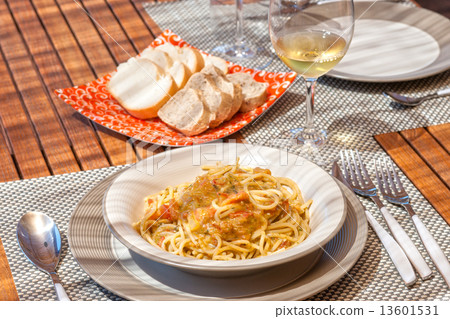 Spaghetti with tomato and pesto sauce in a teak wood table Spaghetti with tomato and pesto sauce in a teak wood table 13601531