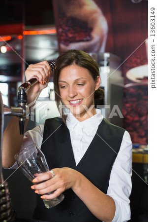 照片素材(图片 happy barmaid pulling a pint of beer