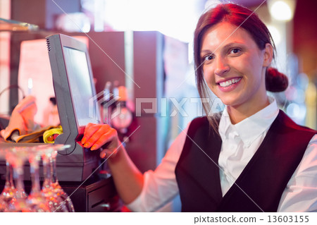 Happy barmaid using touchscreen till Happy barmaid using touchscreen till 13603155