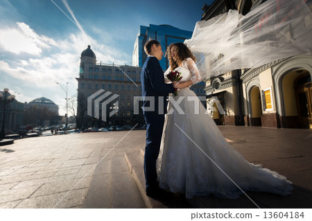 elegant newly married couple hugging on street 13604184