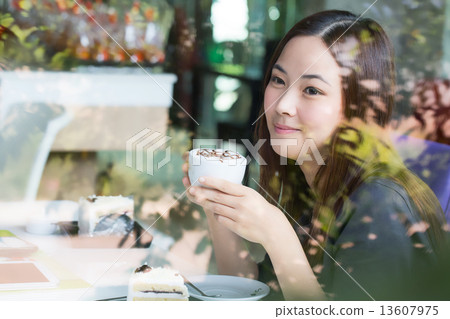 Young Asian women holding a cup of coffee beside mirror Young Asian women holding a cup of coffee beside mirror 13607975
